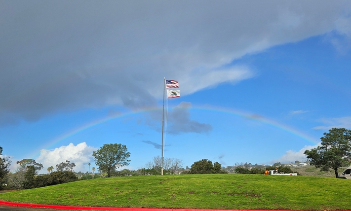 Kate Sessions full Rainbow behind waving flags